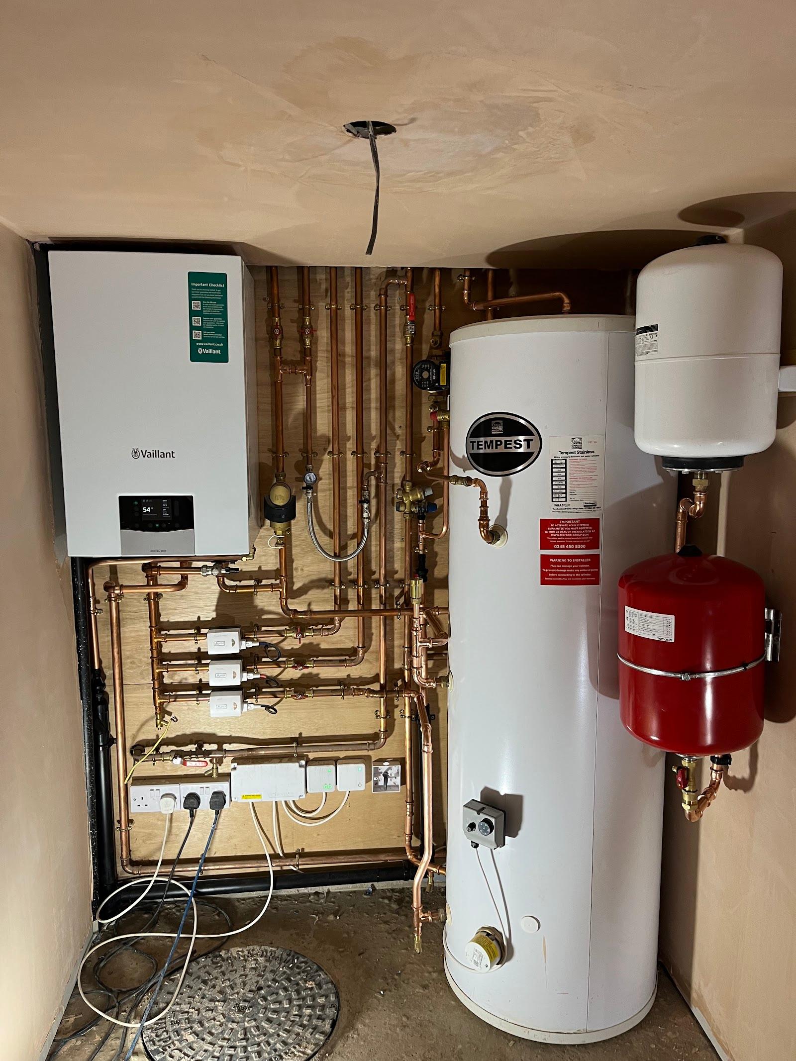 A Vaillant system boiler fitted beside an unvented hot water cylinder, with copper pipework and two expansion vessels
