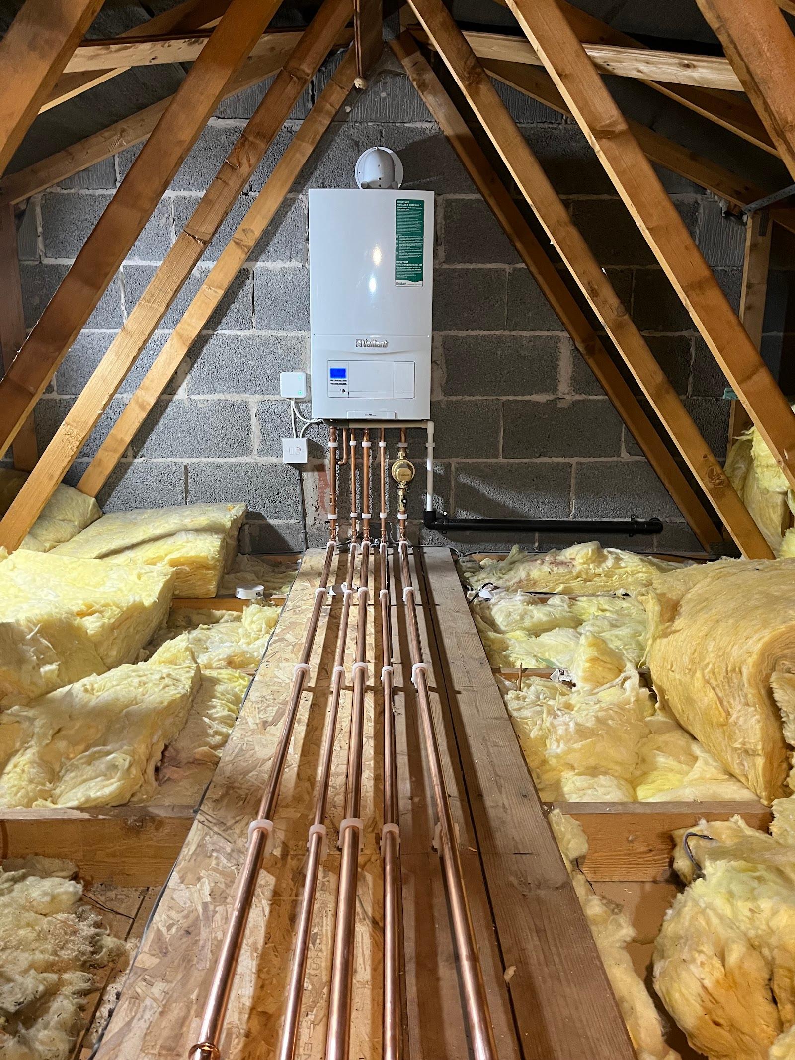 A boiler installed in a loft, with the pipework run neatly between the joists