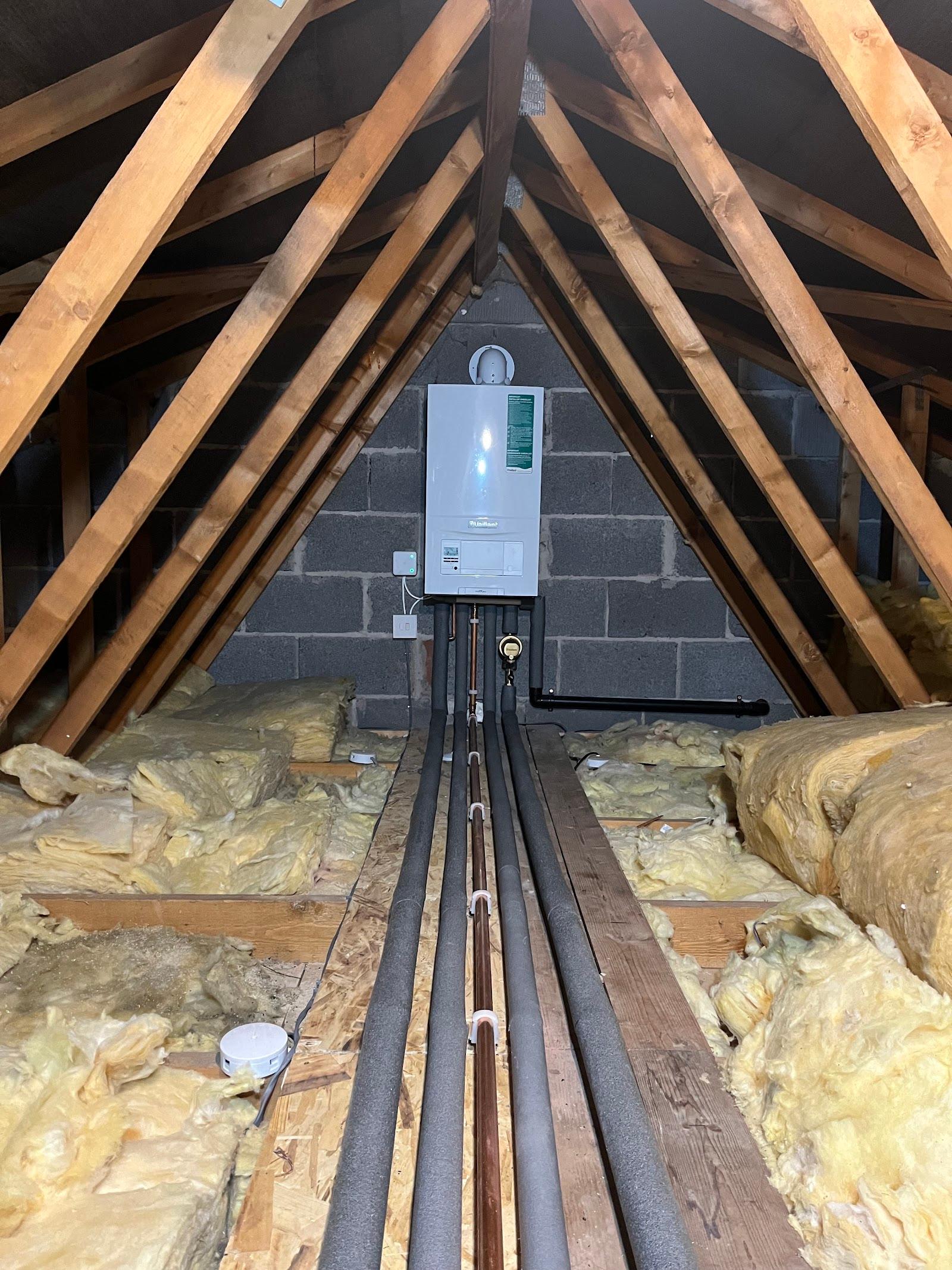 A boiler and pipework installed in a loft space